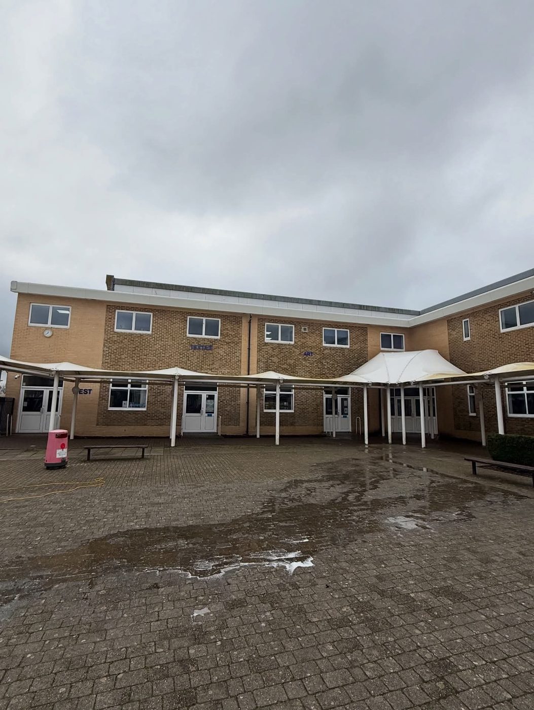 White tensile canopies and fascias at a school courtyard before cleaning in West Sussex