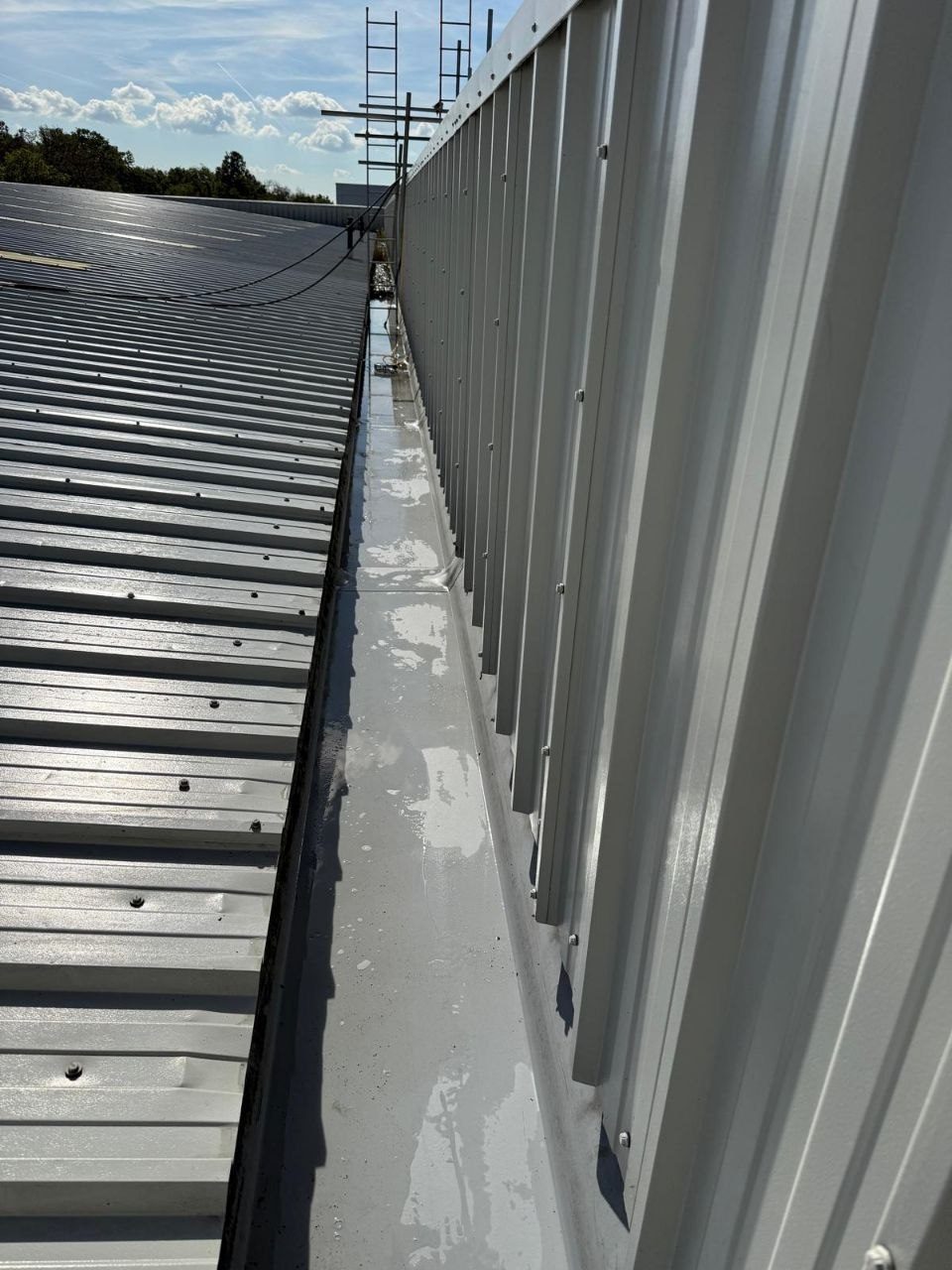 Cleaning an industrial metal roof and box gutter at height in West Sussex